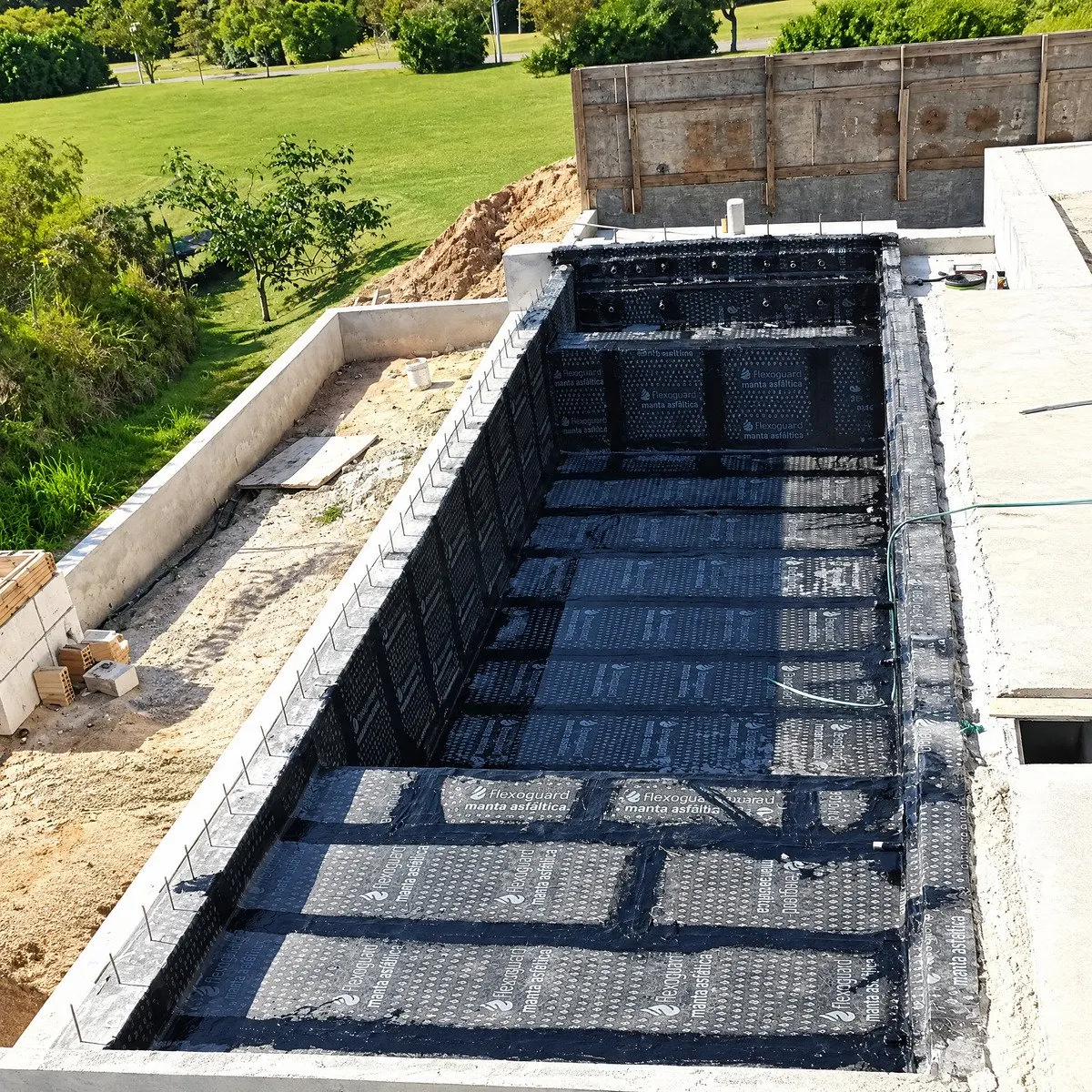Piscina de alvenaria com manta asfáltica Flexoguard — estrutura selada antes do revestimento