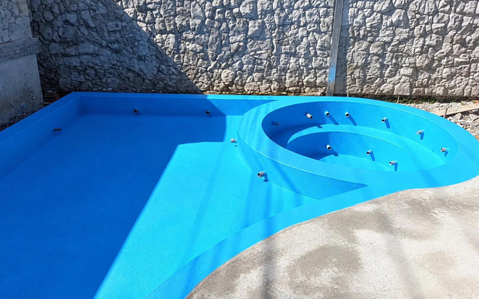 Piscina com sistema de membrana azul contínua e spa circular — acabamento impermeável ImperMais