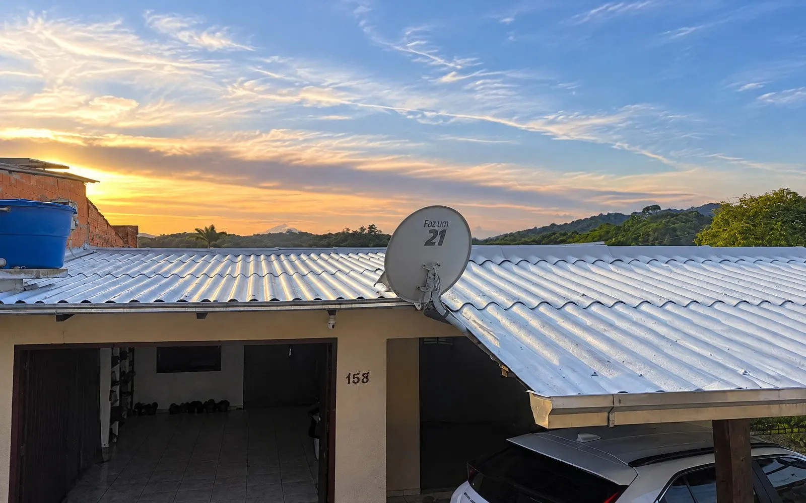 Telhado residencial com borracha líquida / membrana refletiva ao entardecer — capa do serviço