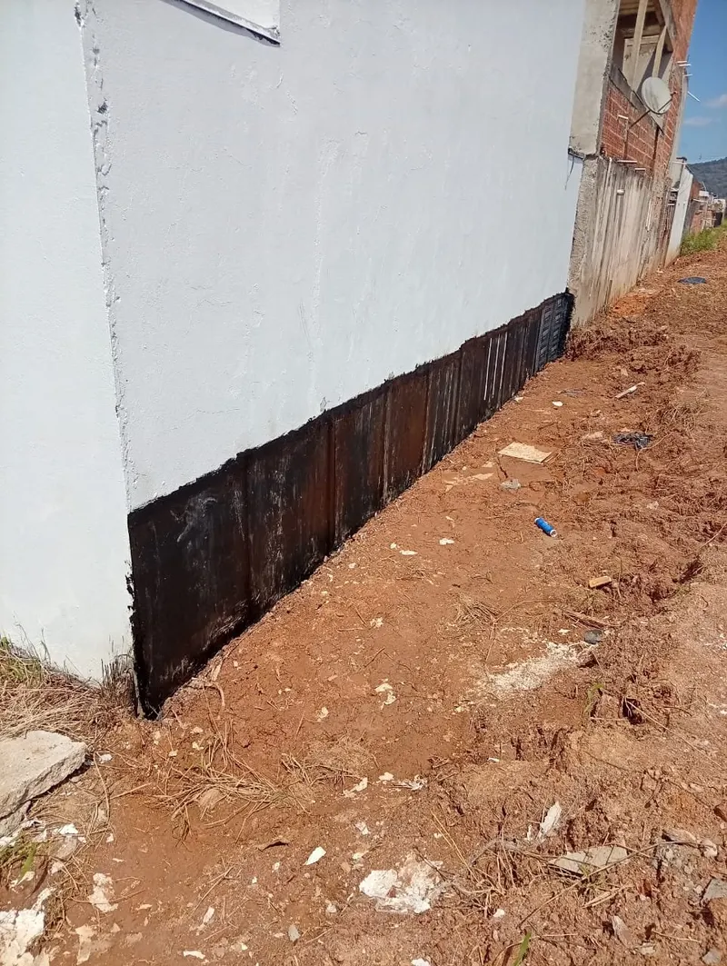 Base de muro com impermeabilização asfáltica na faixa de contato com o solo