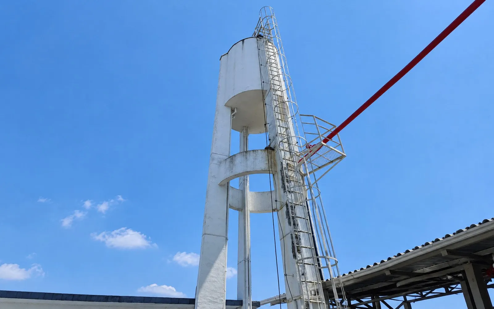 Caixa d’água elevada de concreto com escada de acesso e tubulação — capa do serviço ImperMais
